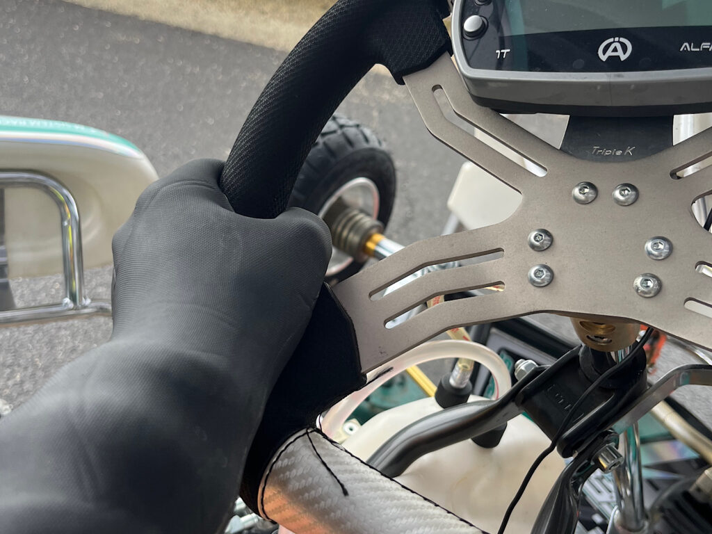 VeloTozeの防水グローブを着けてカートのステアリングを握る手